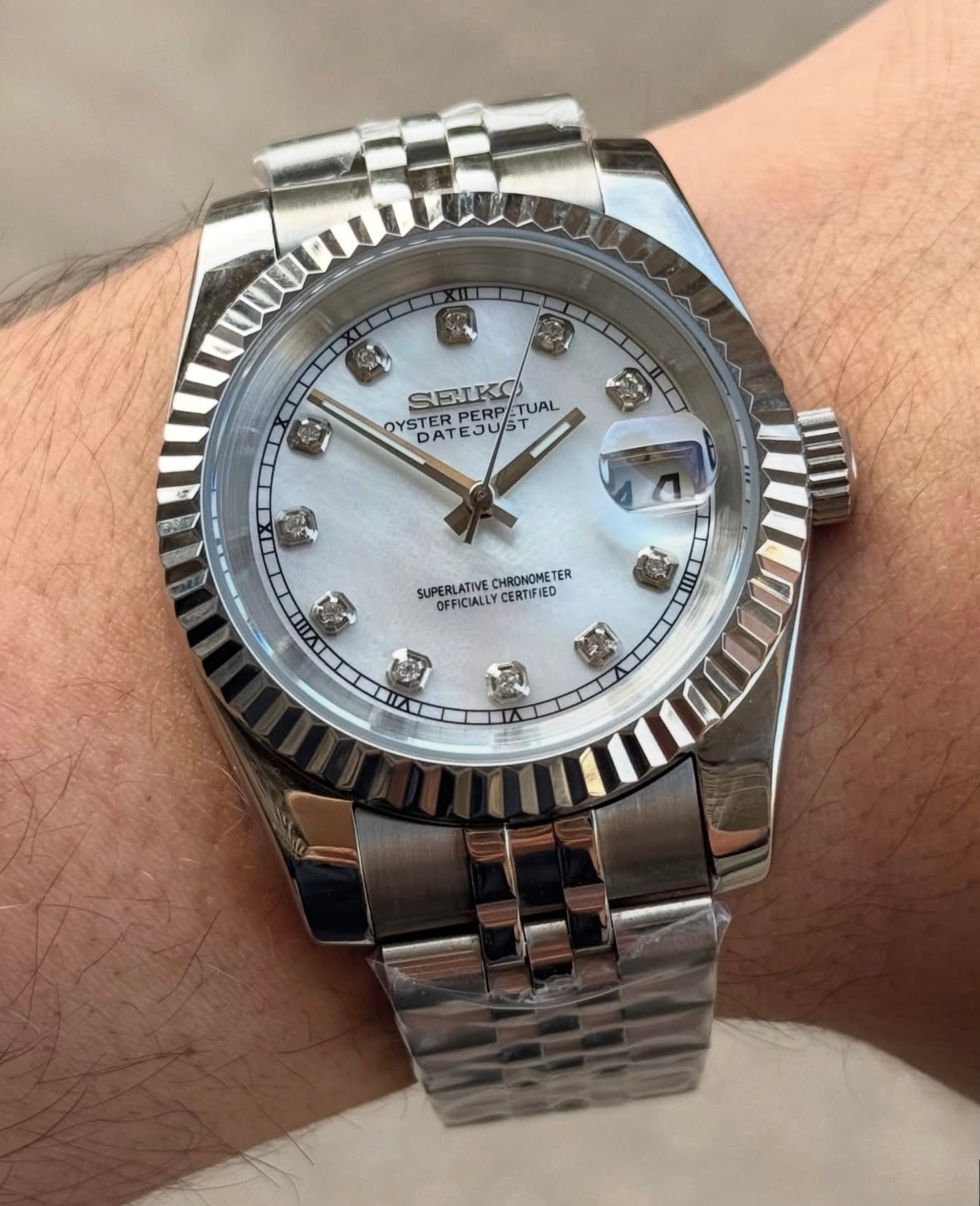 white diamond dial stainless steel Seiko NH35 mod watch on jubilee bracelet, wrist shot